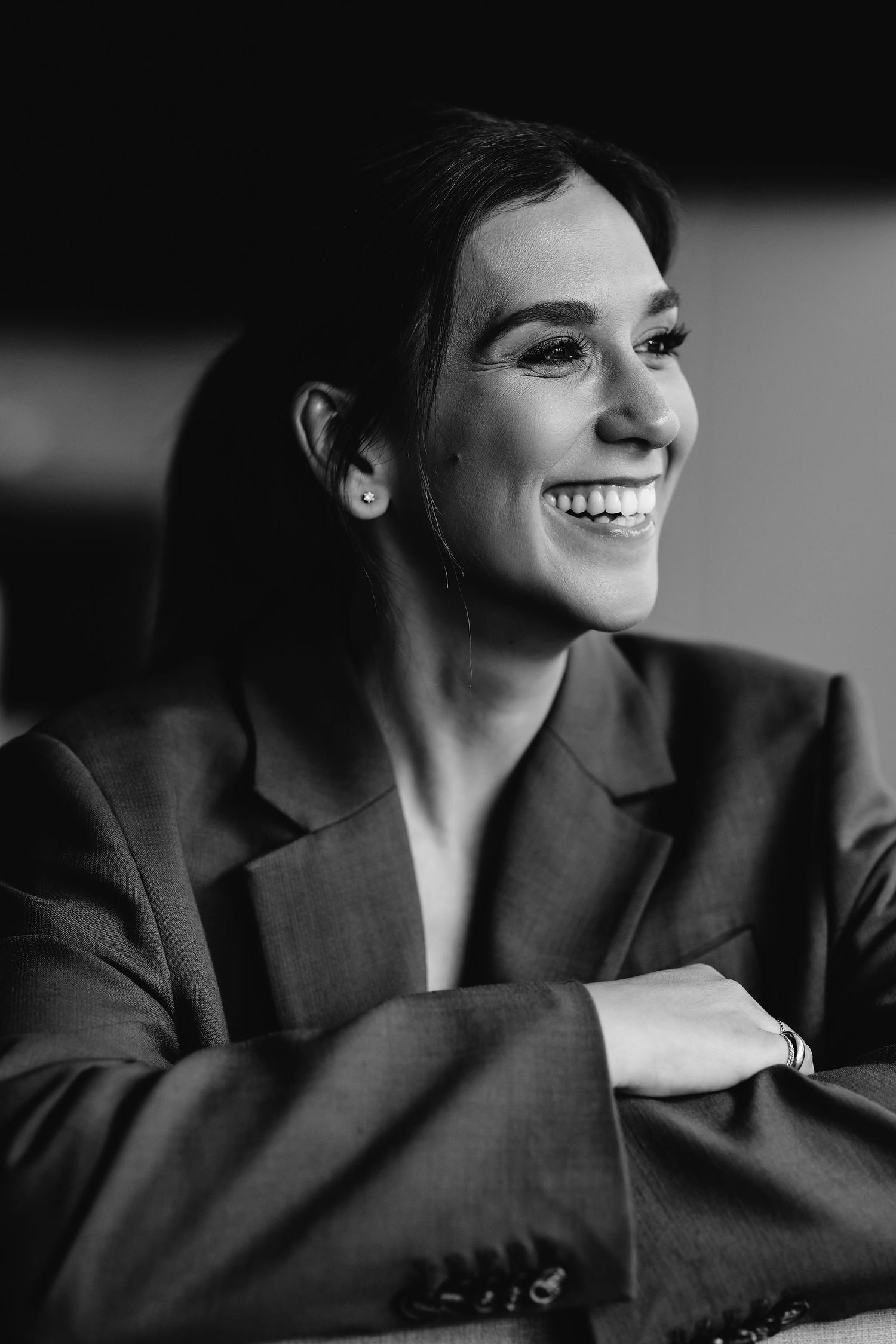 Black and white portrait showing joyful expression and professional attire.