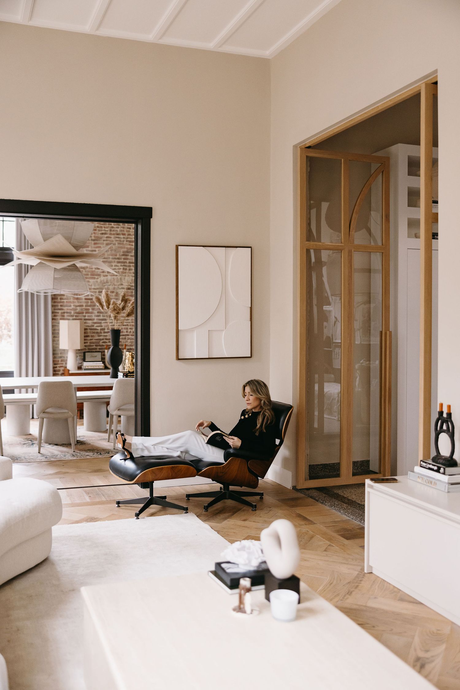 Interior view of modern living room with person relaxing in leather lounge chair.