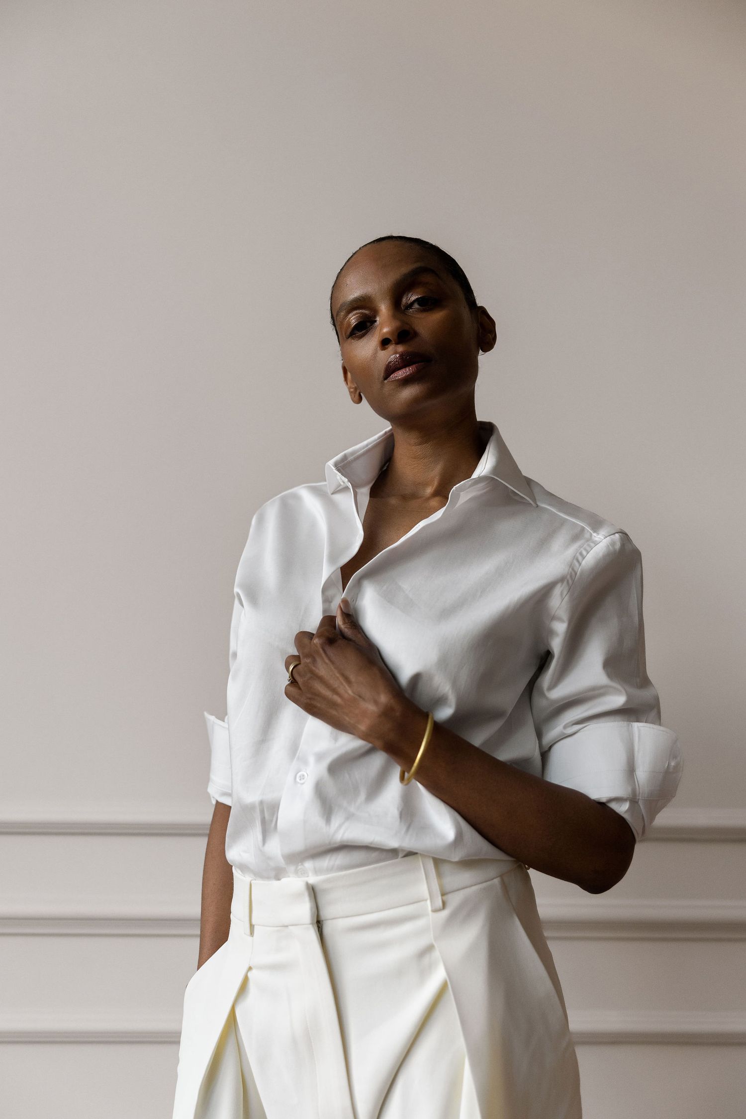 Minimalist fashion portrait featuring an all-white ensemble with crisp button-down shirt.