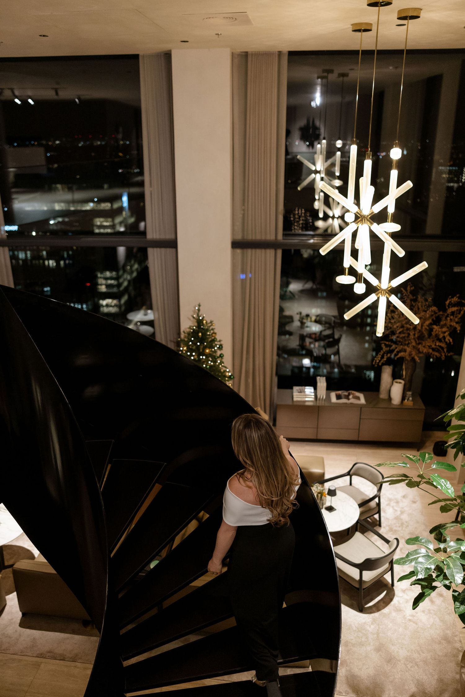 A modern staircase and snowflake light fixture create an elegant evening atmosphere.