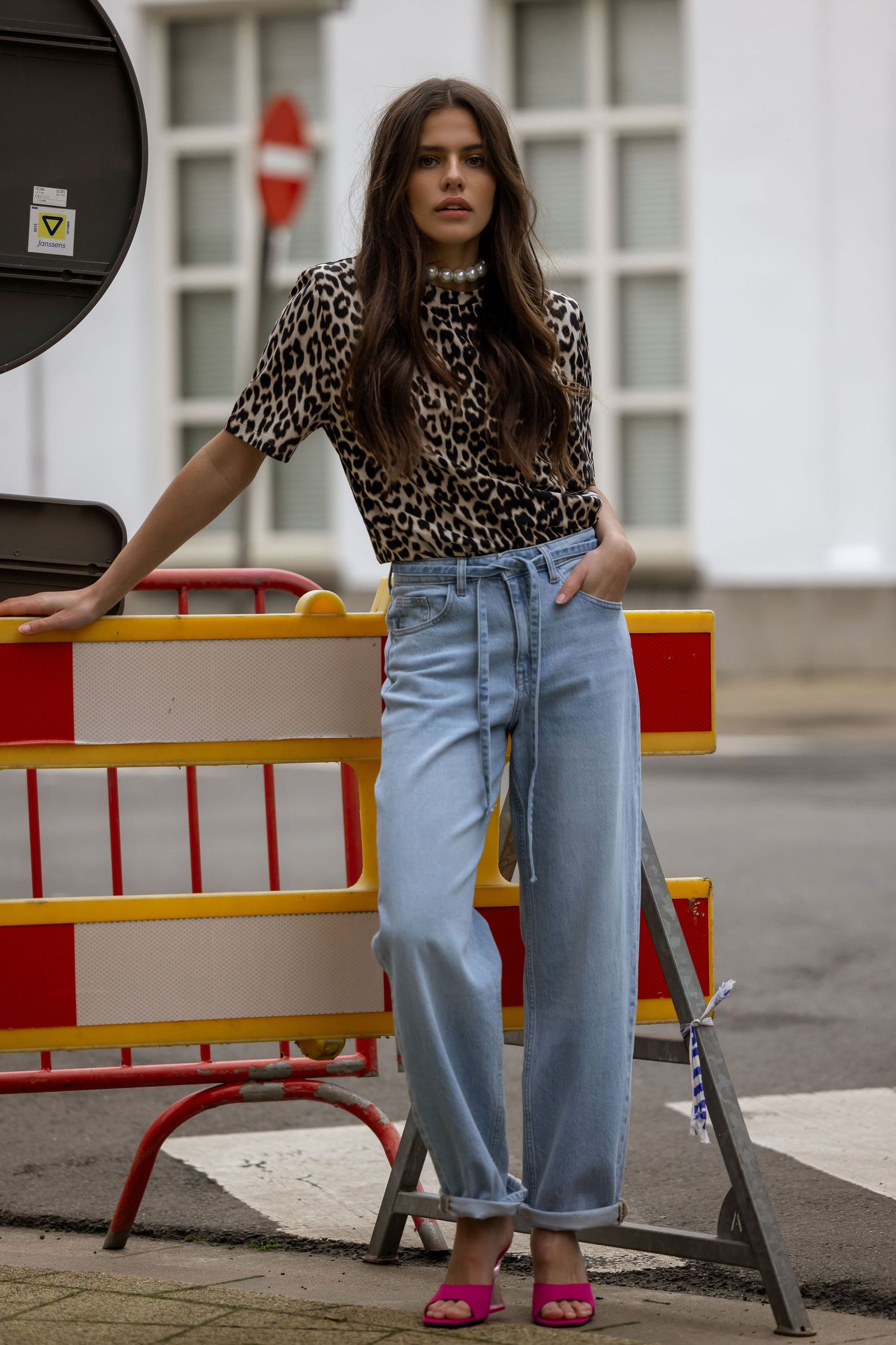 Street style outfit featuring leopard print top with wide-leg jeans and pink sandals.