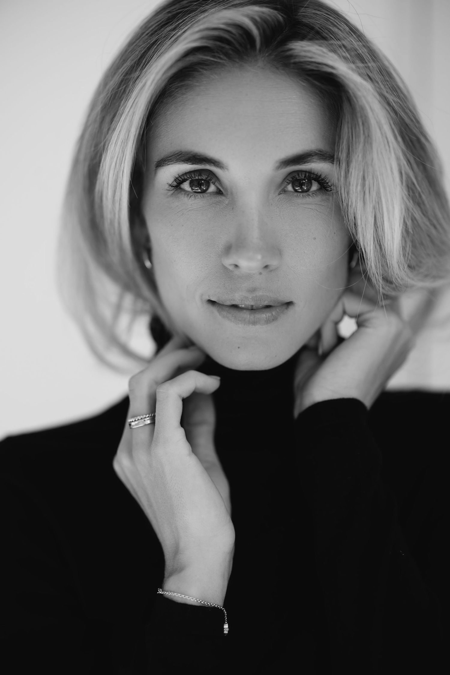 Black and white portrait showing elegant pose in dark turtleneck sweater.