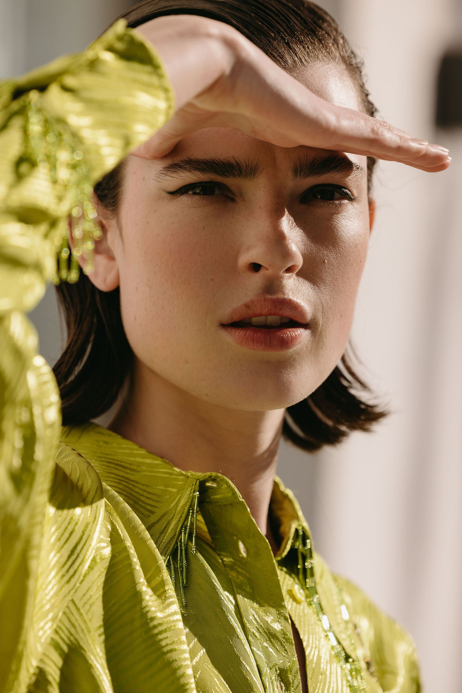 Portrait shot showcasing bright chartreuse textured top with dramatic lighting and shadows.