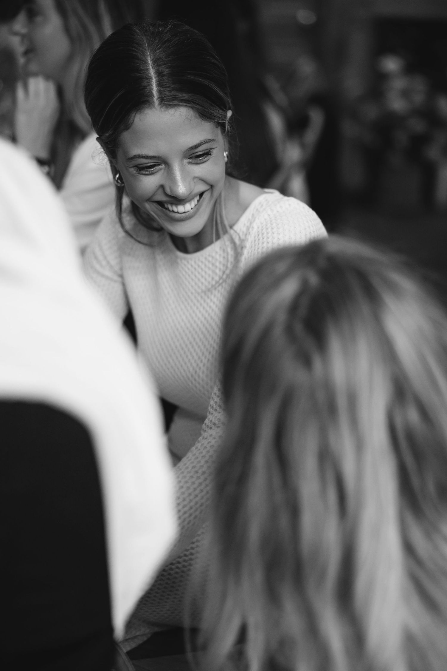 Black and white candid shot of social gathering with warm atmosphere.