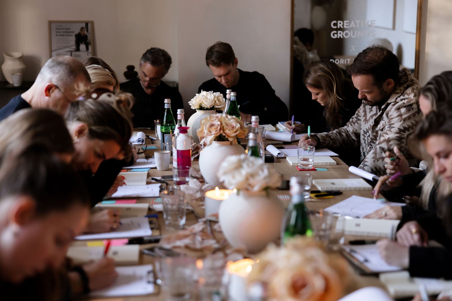 Group gathering around a long dining table with drinks and place settings.