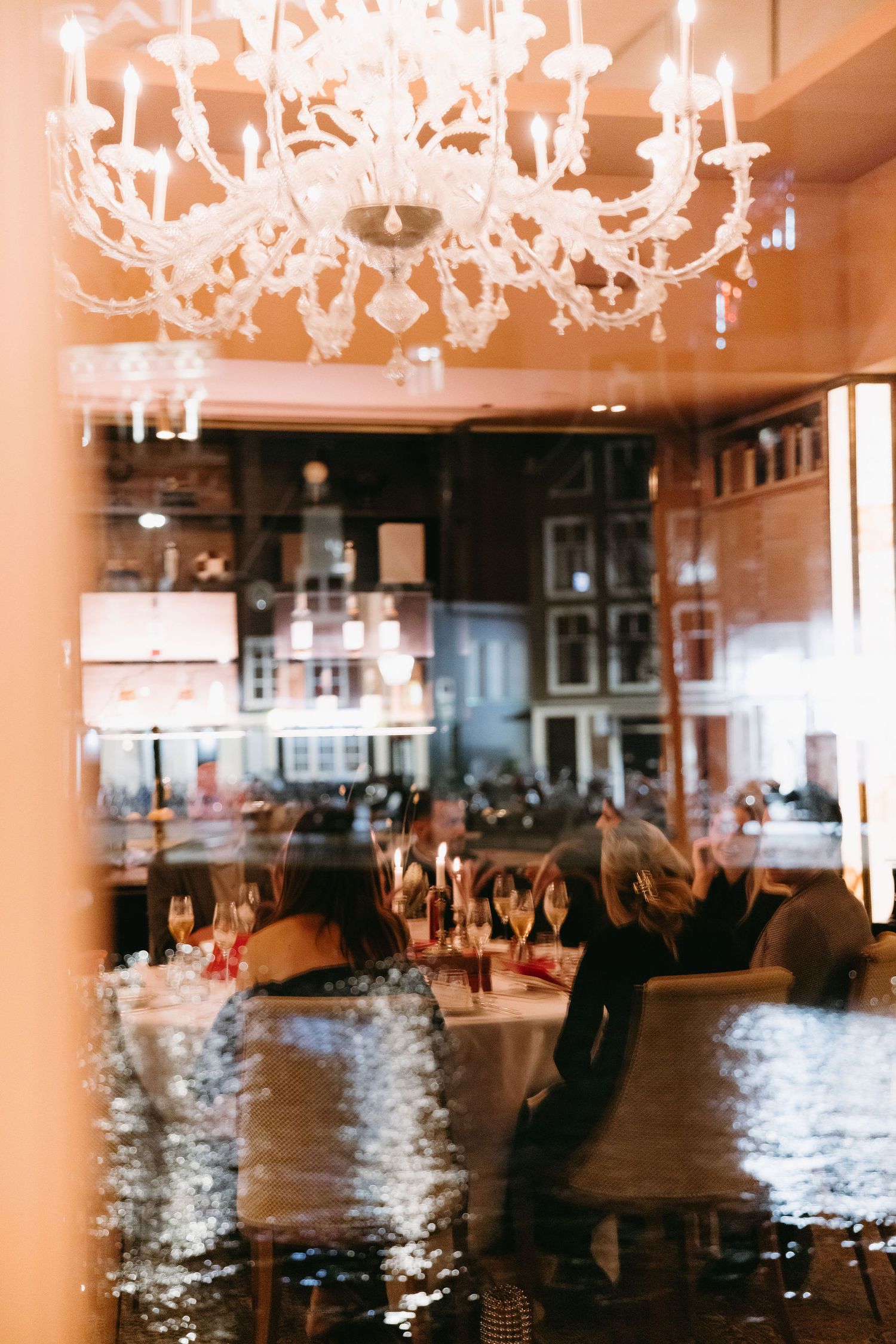 Dimly lit restaurant interior with romantic crystal chandelier and table settings.