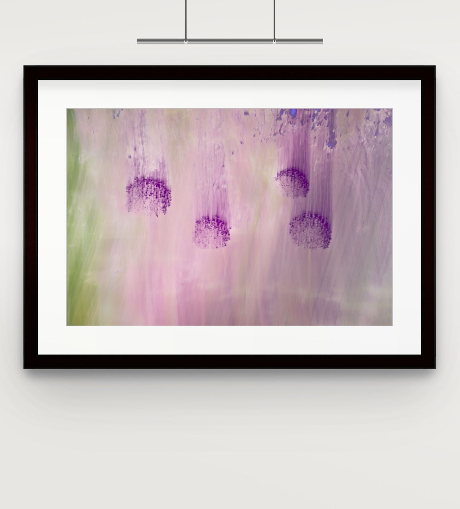 Framed abstract purple and green floral artwork hanging on a white wall in a minimalist setting.