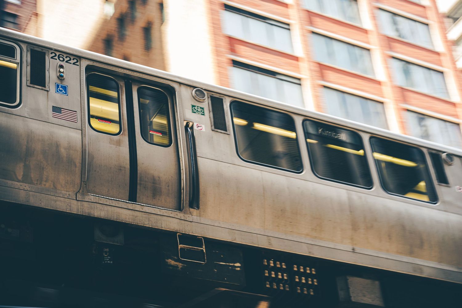 Chicago elevated L train passing between urban buildings, low angle view.