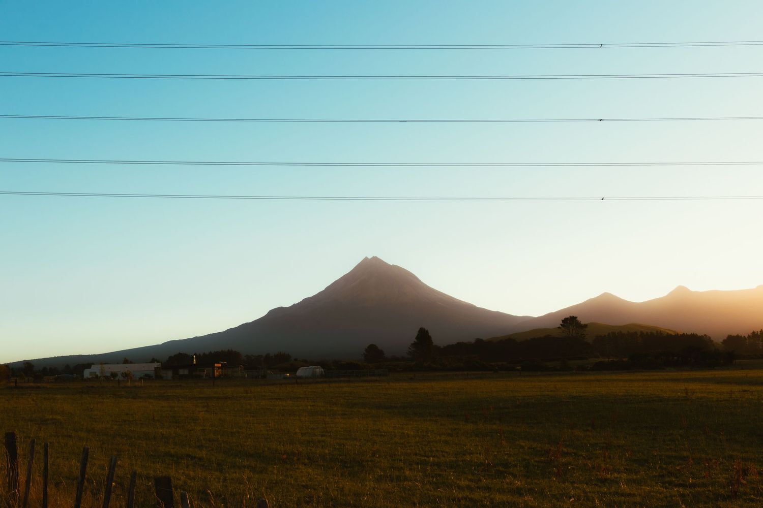 Mount Taranaki at sunset viewed from rural farmland in Taranaki, New Zealand.