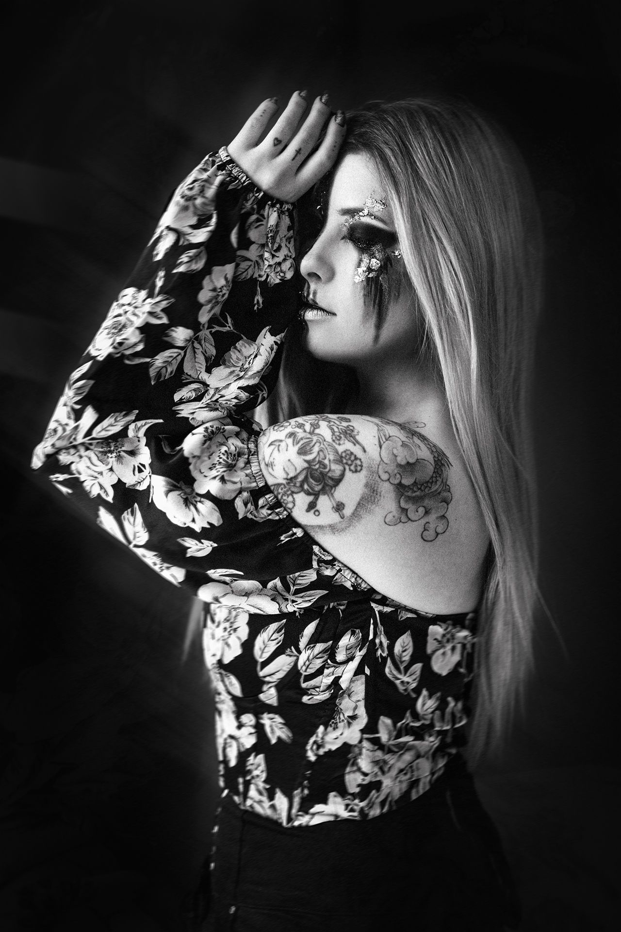Creative black and white portrait of a tattooed woman with dramatic floral styling