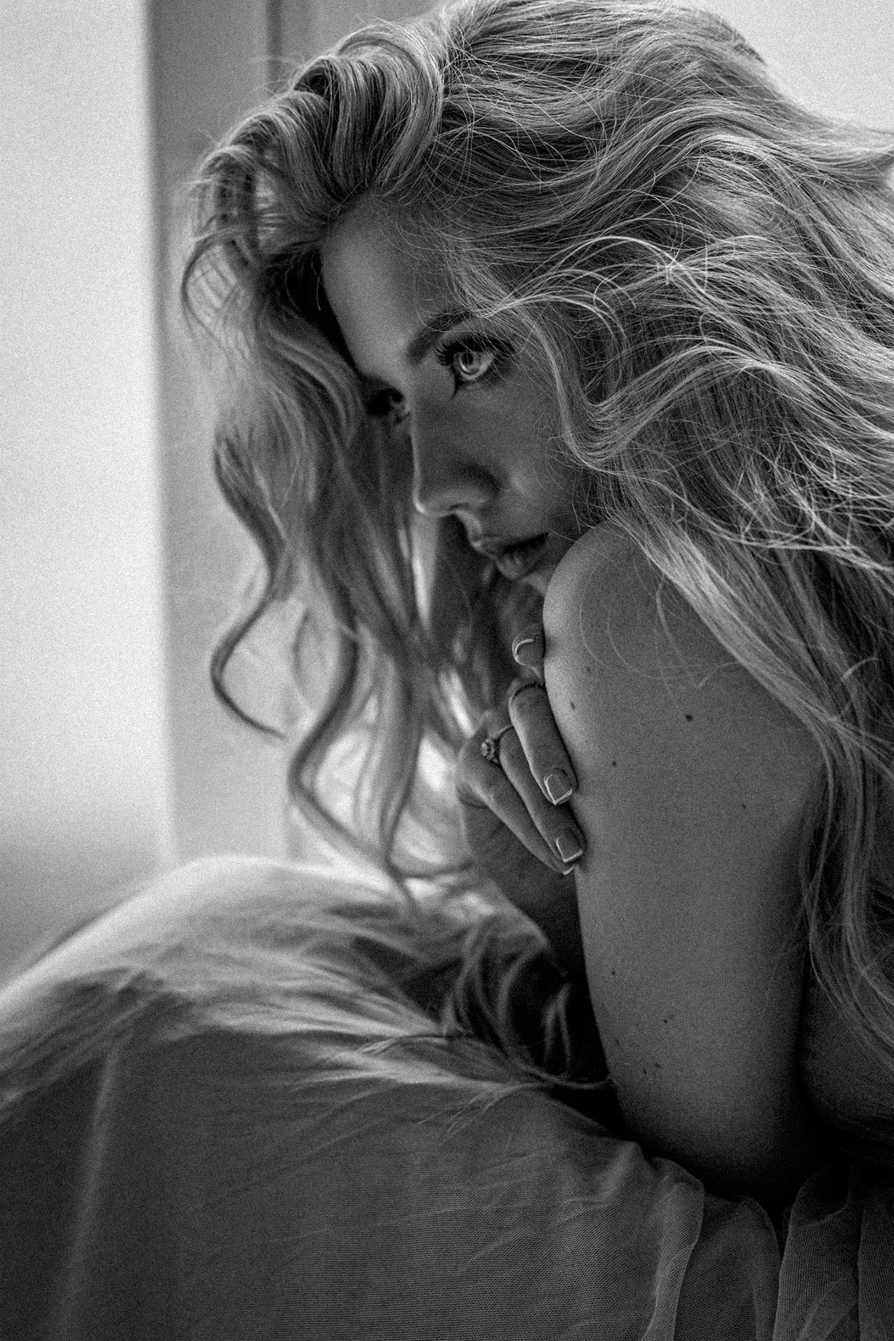 Emotional black and white portrait of a woman on a bed, premium women's portrait photography