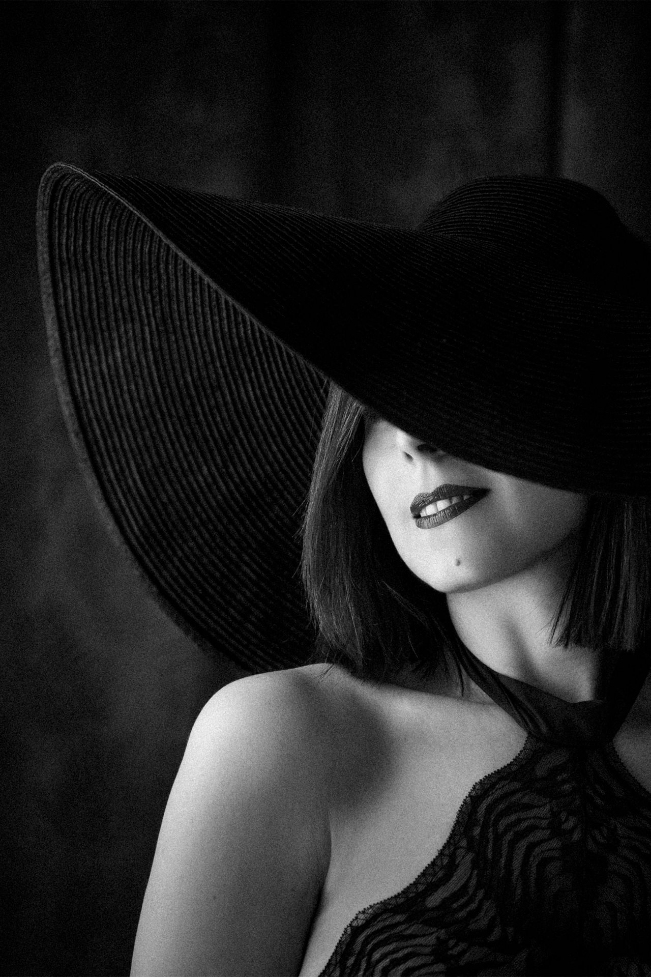 Black and white women's portrait with a wide brim hat by Martyna Osuchowska, portrait photographer in Częstochowa