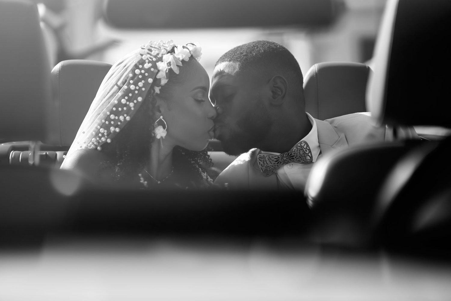 Baiser des mariés au travers du par-brise d'une voiture, noir et blanc »