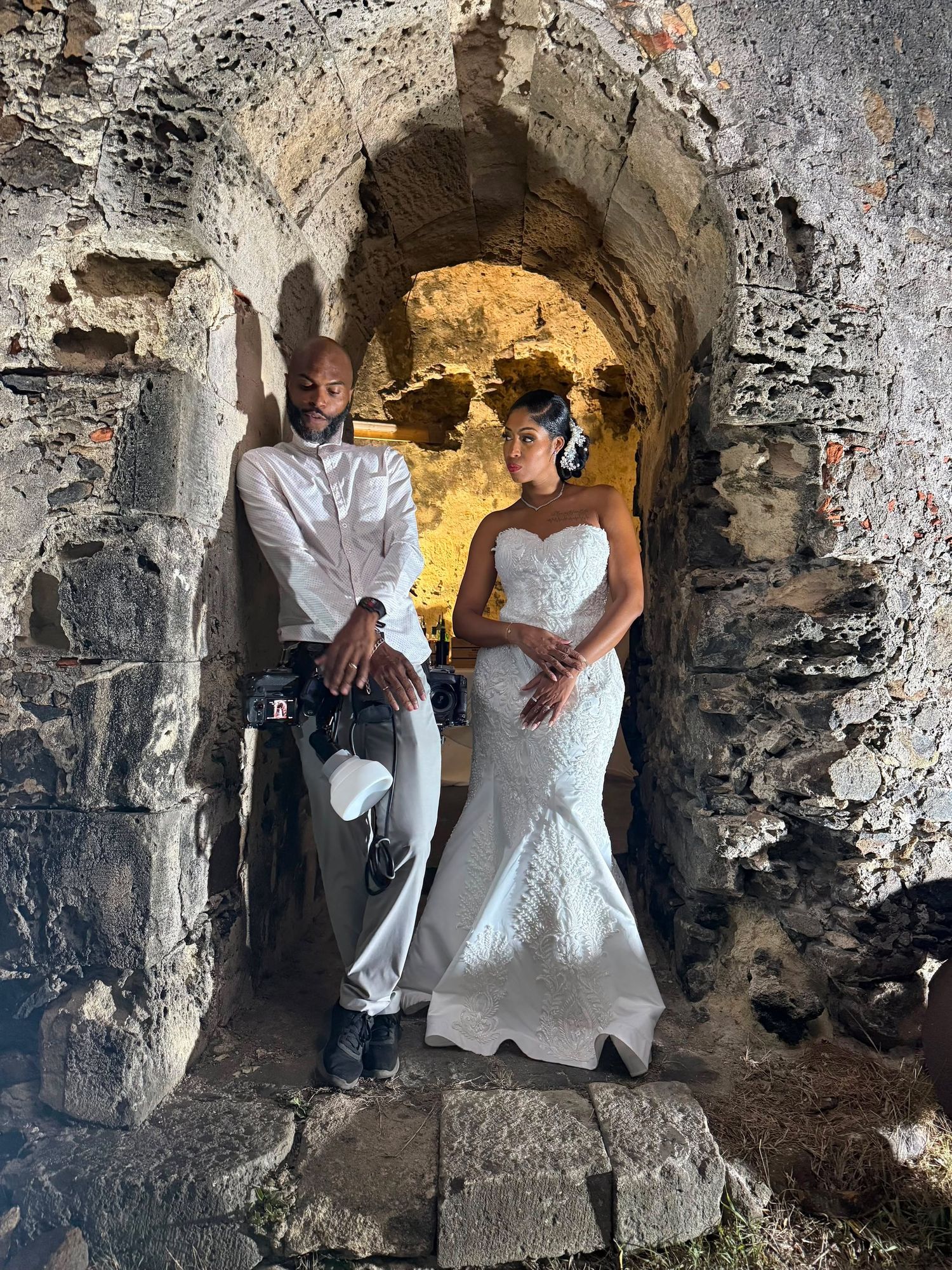 Photographe en pleine direction de modèle avec la mariée lors de la séance photos nocturne à l'entrée d'un moulin