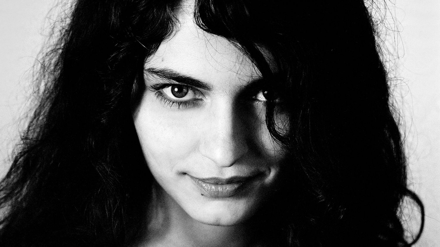 Black and white portrait of a young woman with long dark hair and a subtle smile. Marozsán Erika