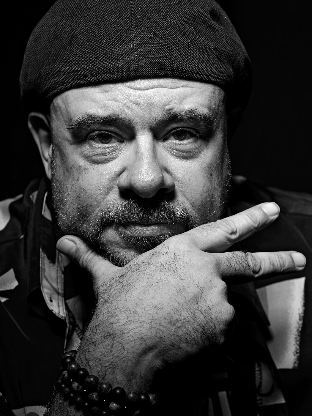 Black and white portrait of a bearded man wearing a beret, resting his chin on his hand with a pensive expression. Bob Franceschini