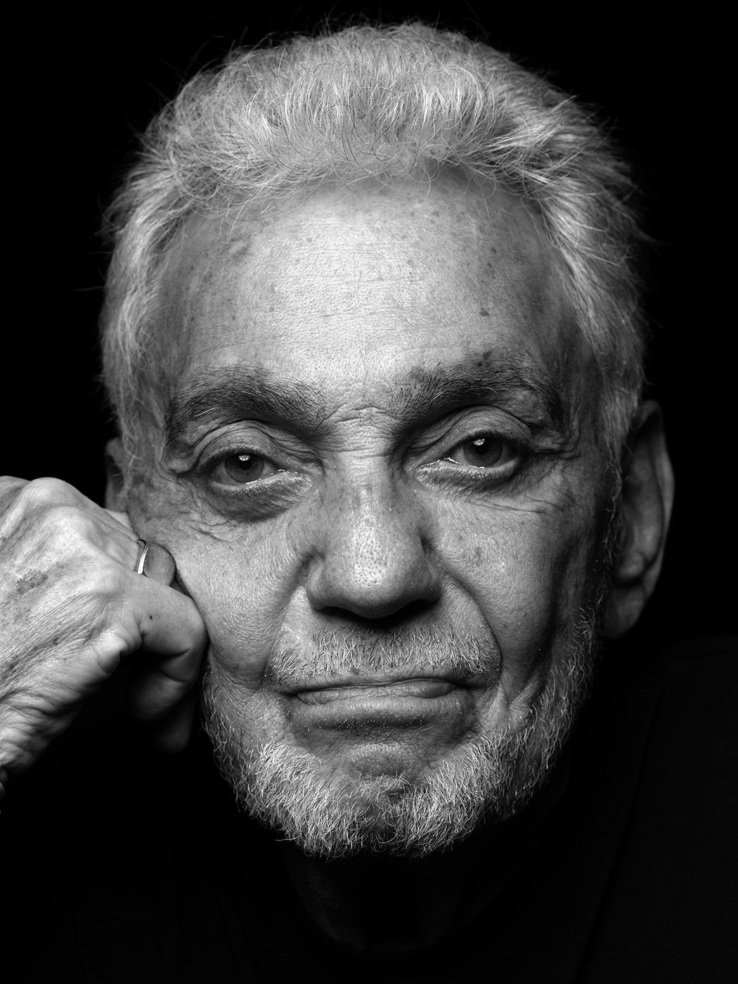 Black and white portrait of an elderly man with gray hair, resting his chin on his hand, looking directly at the camera. Steve Gadd, drummer