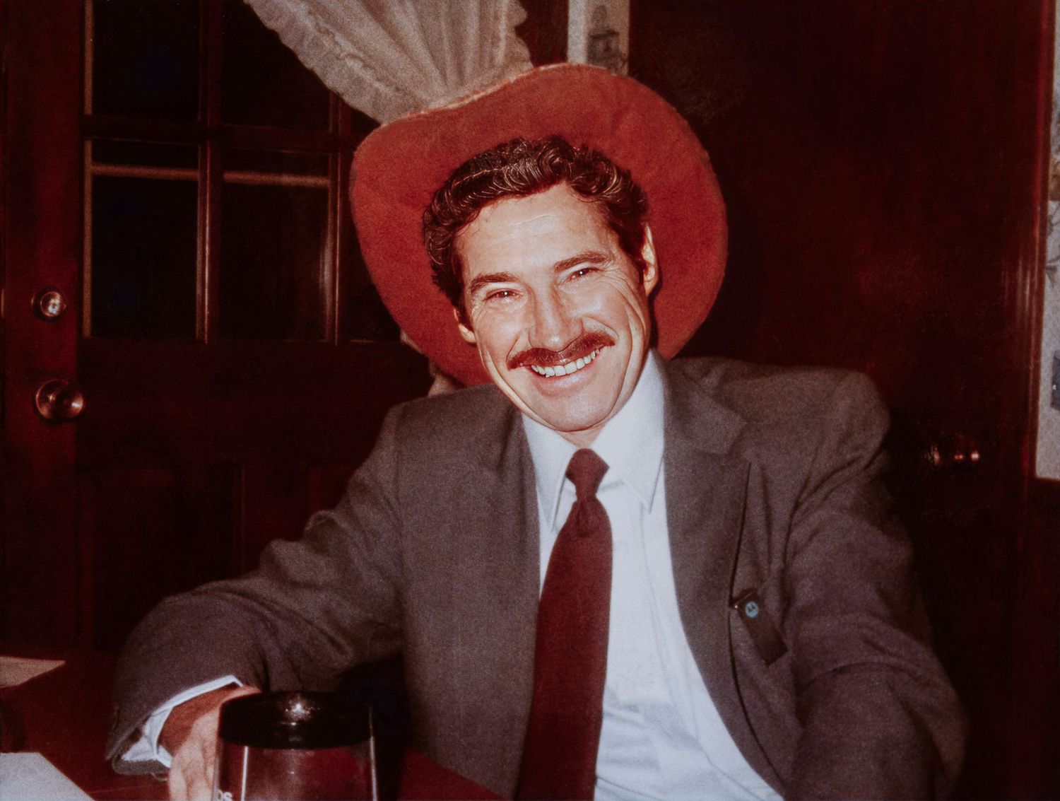 Restored portrait of a man in a red cowboy hat after color and detail repair.