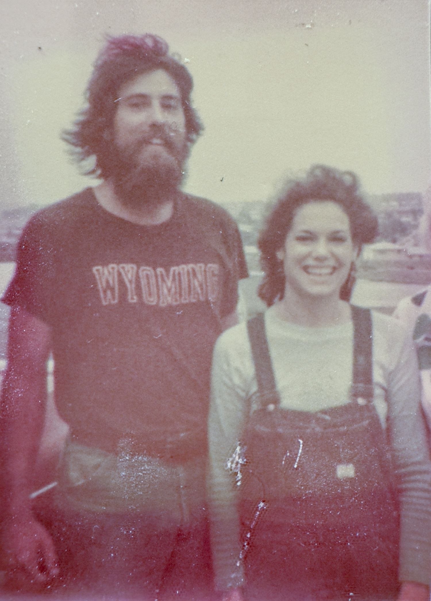 Faded 1970s photograph of a couple before digital photo restoration.