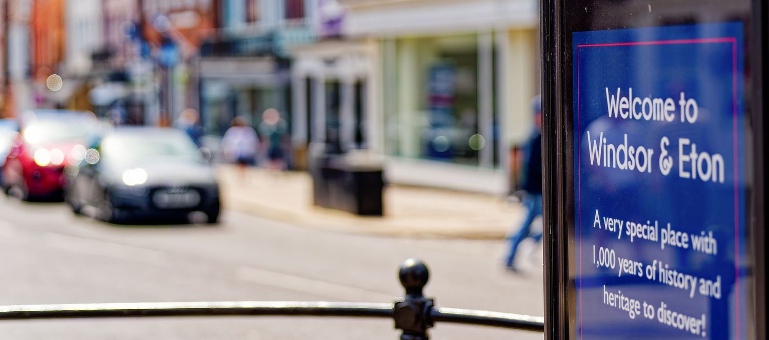 A Welcome to Windsor and Eton sign on a busy historic high street in Berkshire England.