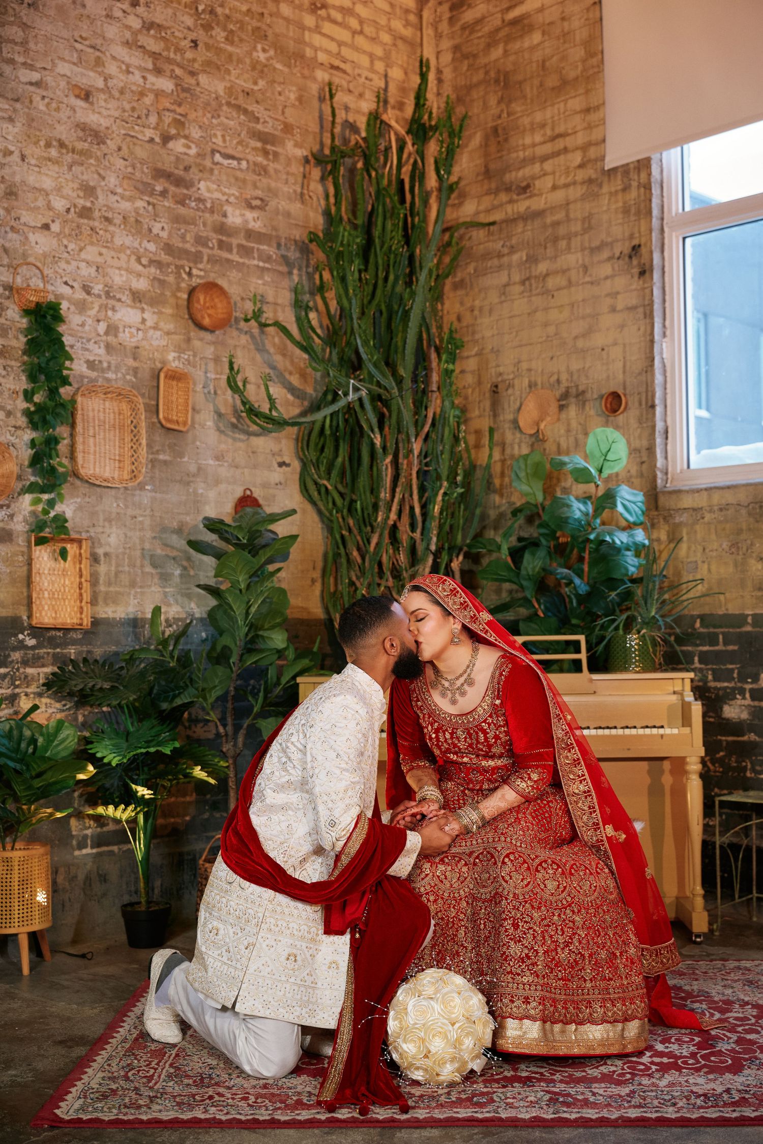 =Couple in traditional red wedding attire seated together, Winnipeg wedding photography
