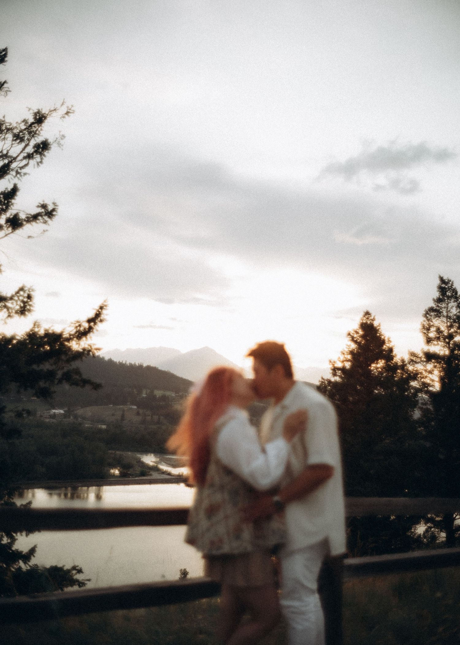 Couple standing on a green hillside overlooking the valley