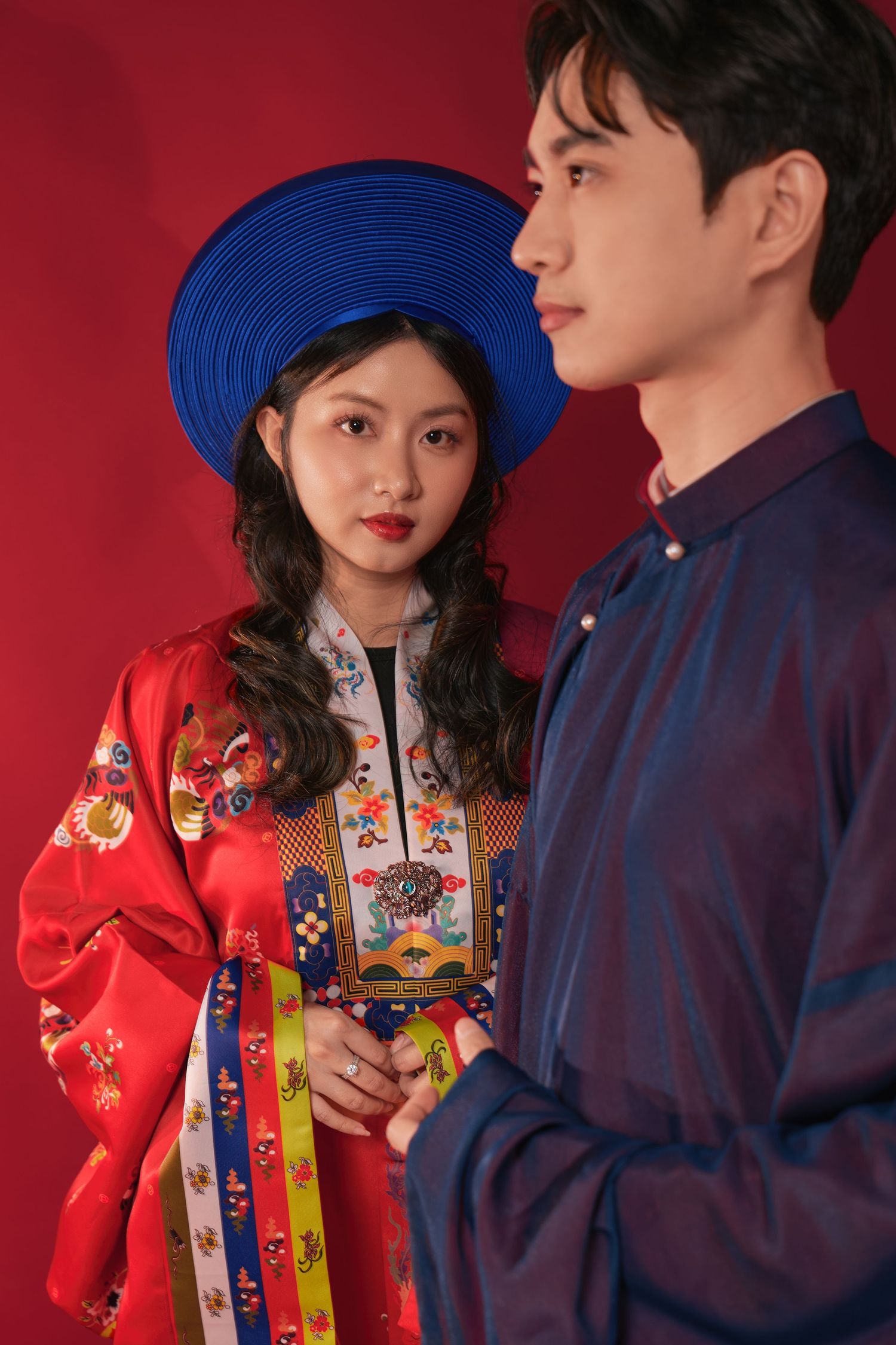 Couple in traditional red wedding attire seated together, Winnipeg wedding photography