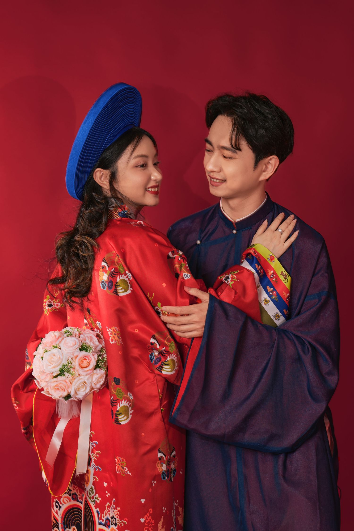 Couple in traditional red wedding attire seated together, Winnipeg wedding photography