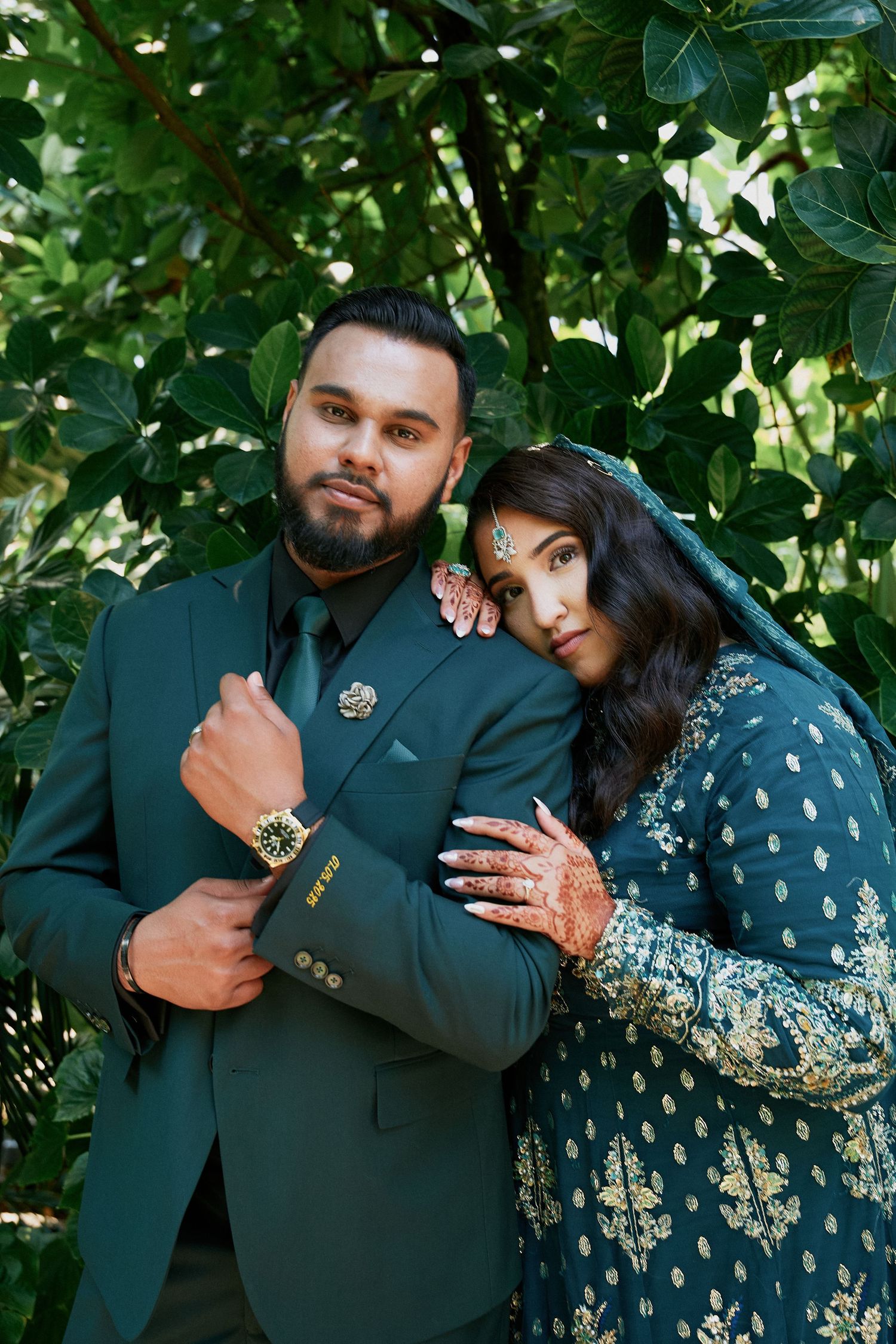Couple in traditional green wedding outfits during their celebration in Winnipeg