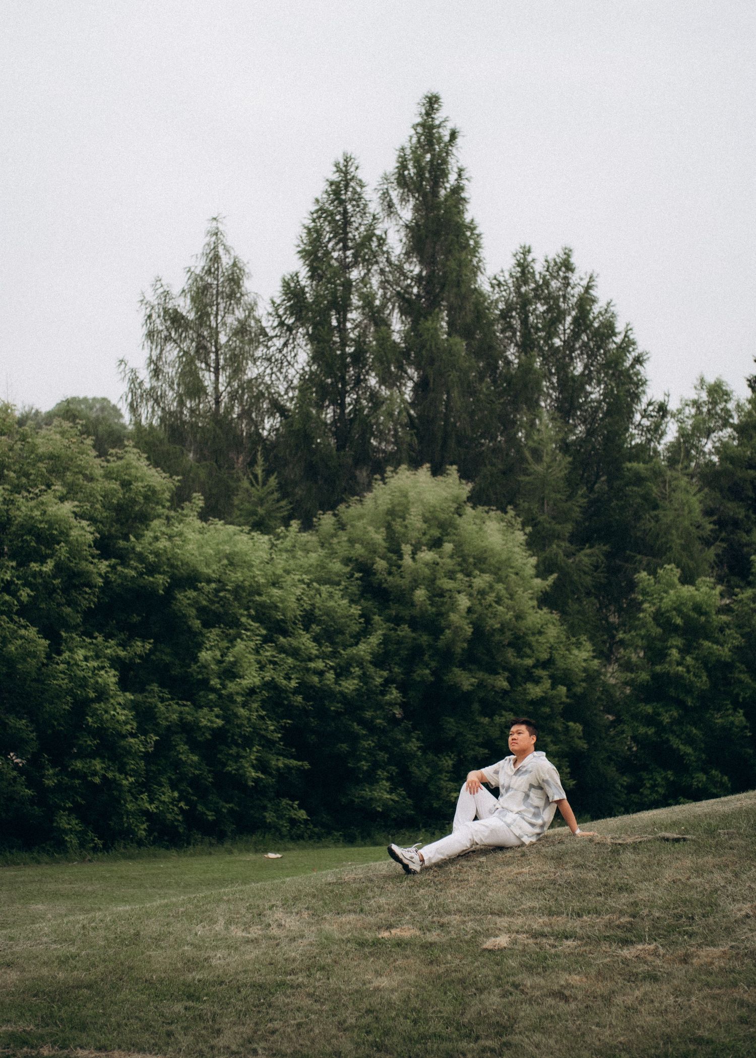Couple standing on a green hillside overlooking the valley