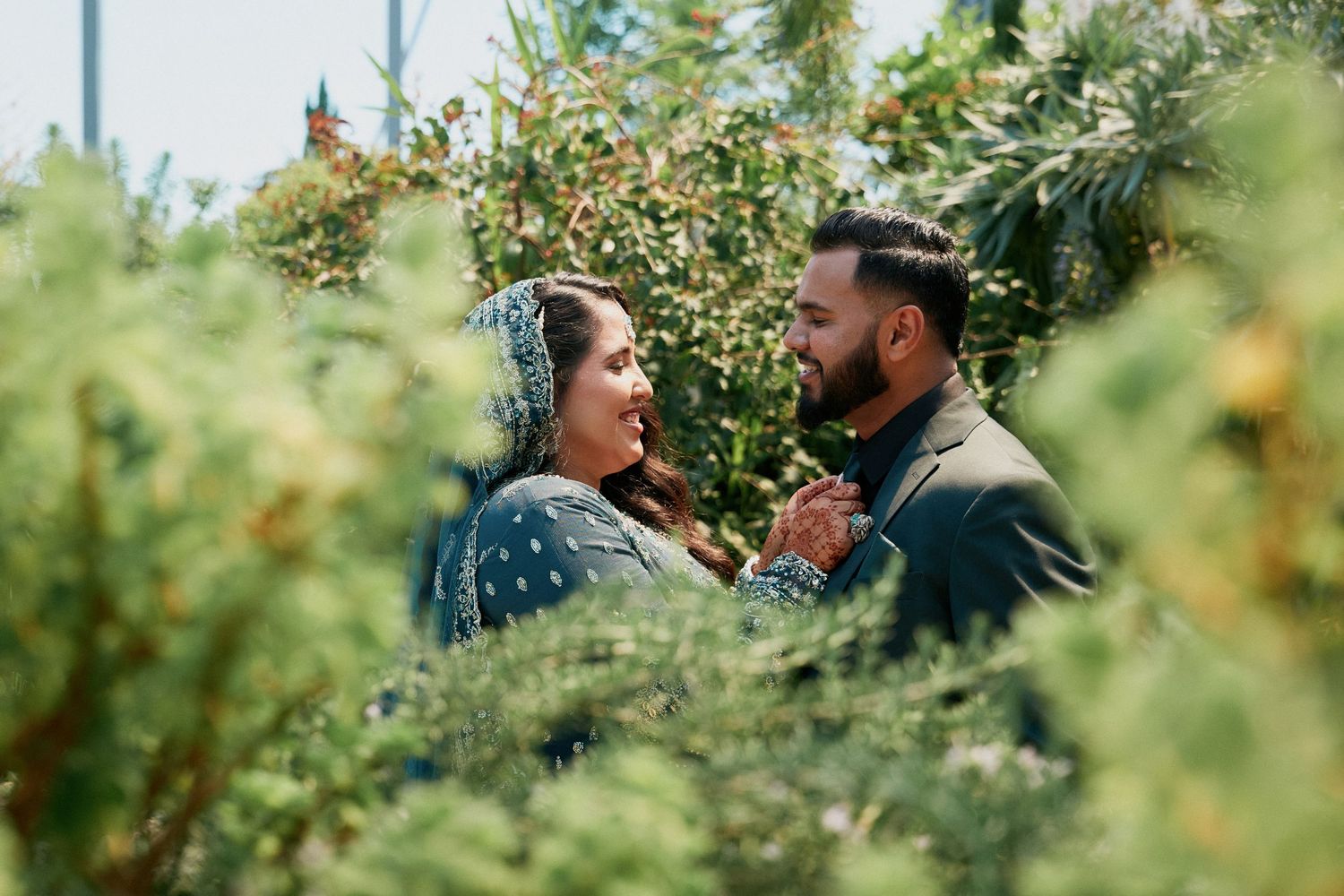 Couple in traditional green wedding outfits during their celebration in the Leaf, Winnipeg