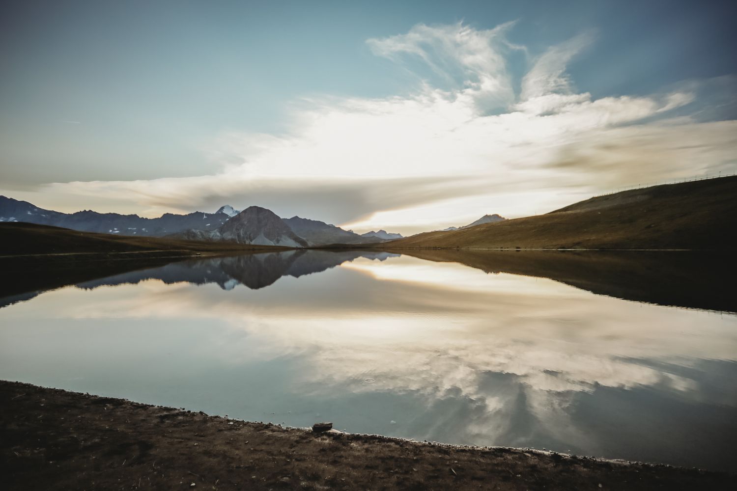 mountain lake reflecting surroundings after sunset