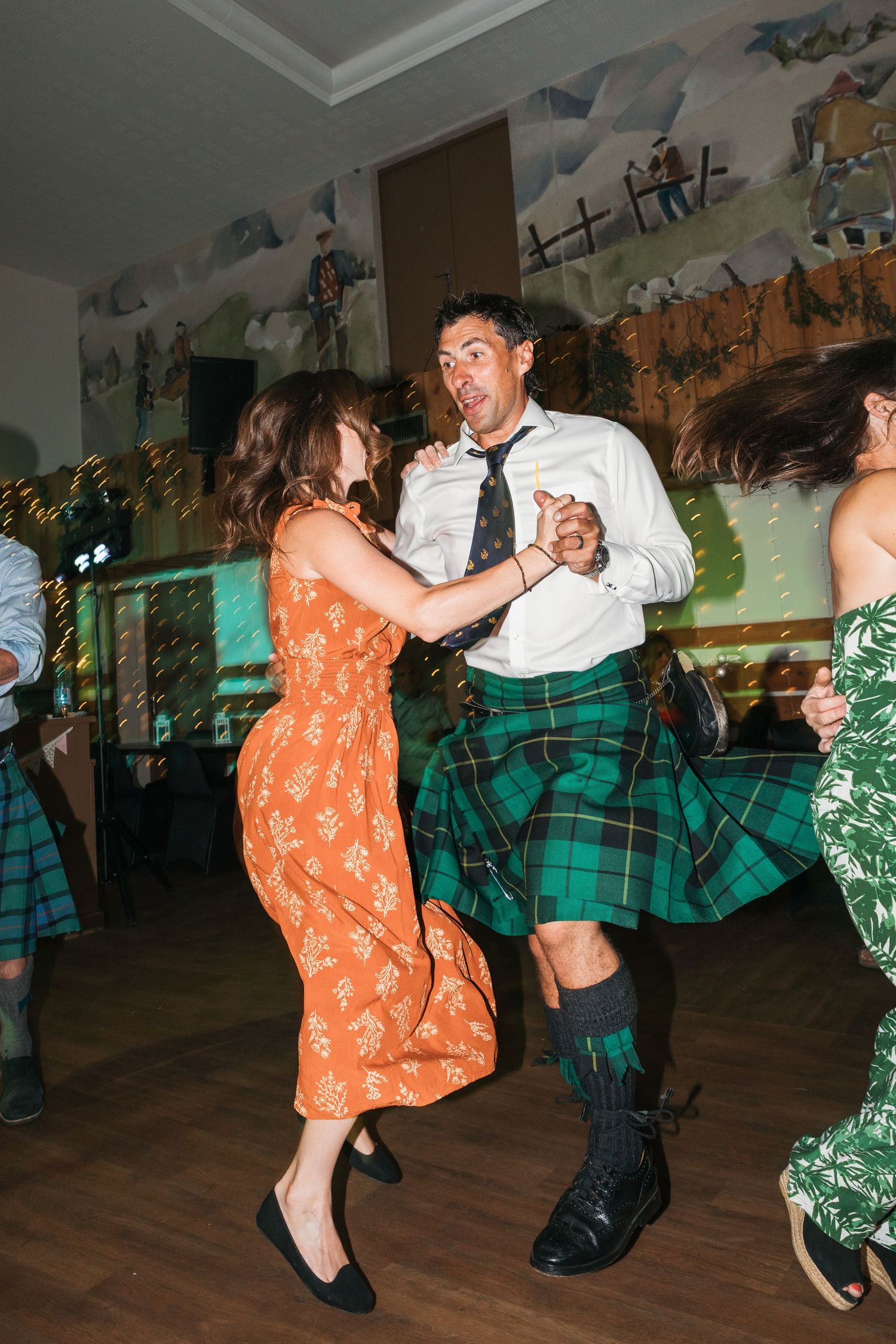 Scottish couple dance the ceilidh wearing a green kilt