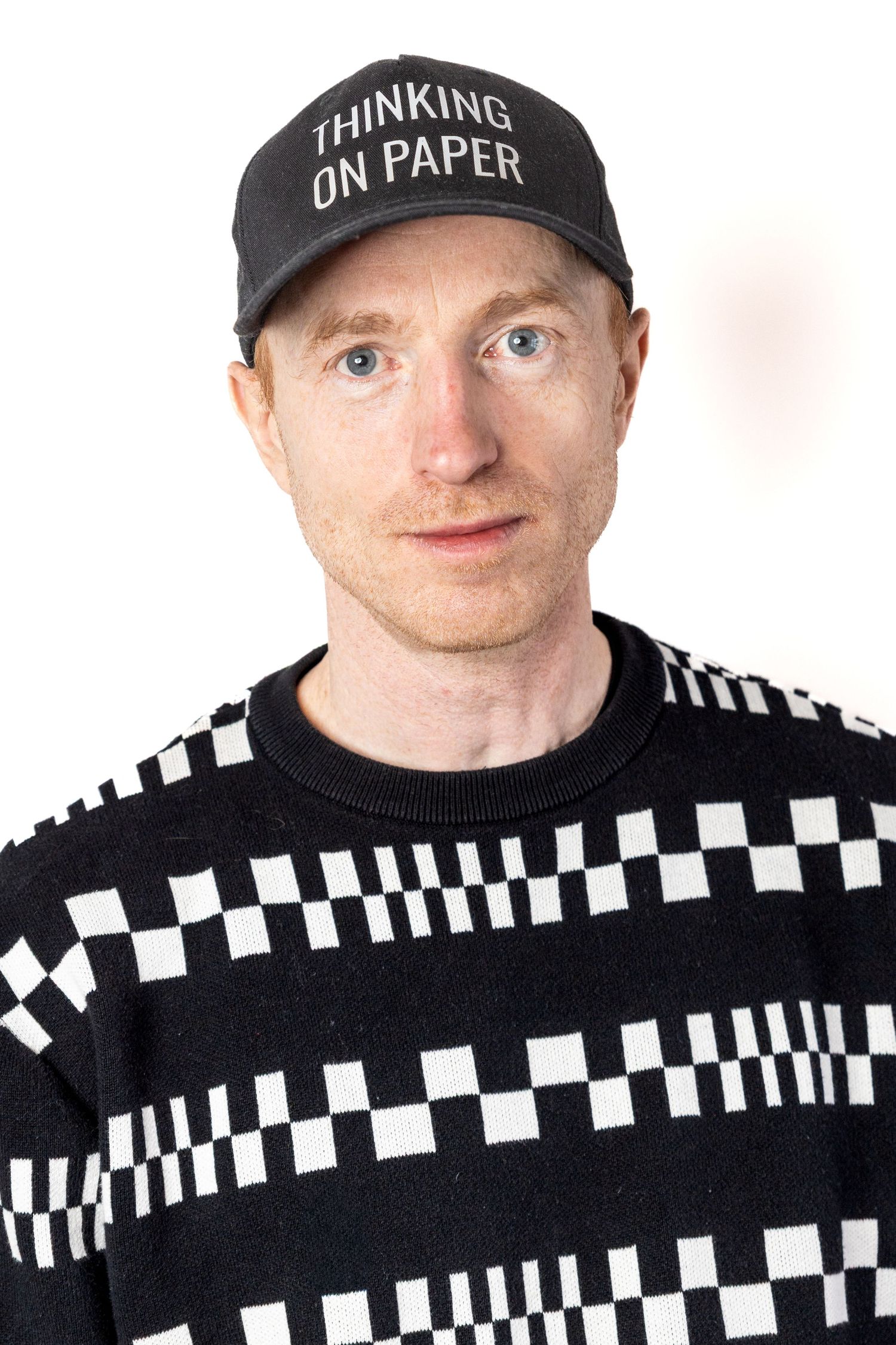 podcaster looking at camera with branded hat