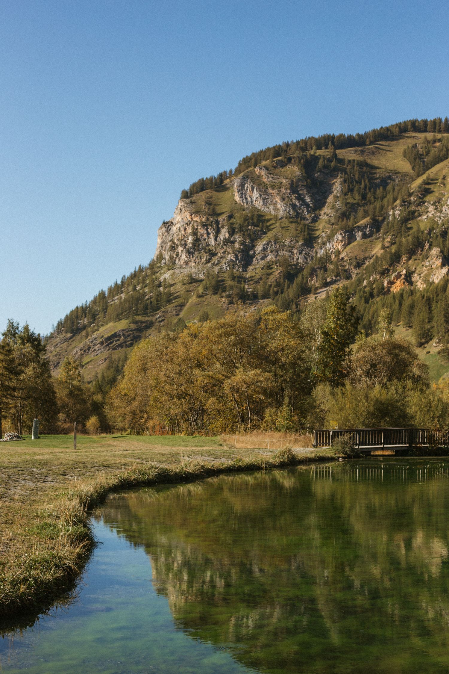 a mountain lake reflects the image of a nearby mountain