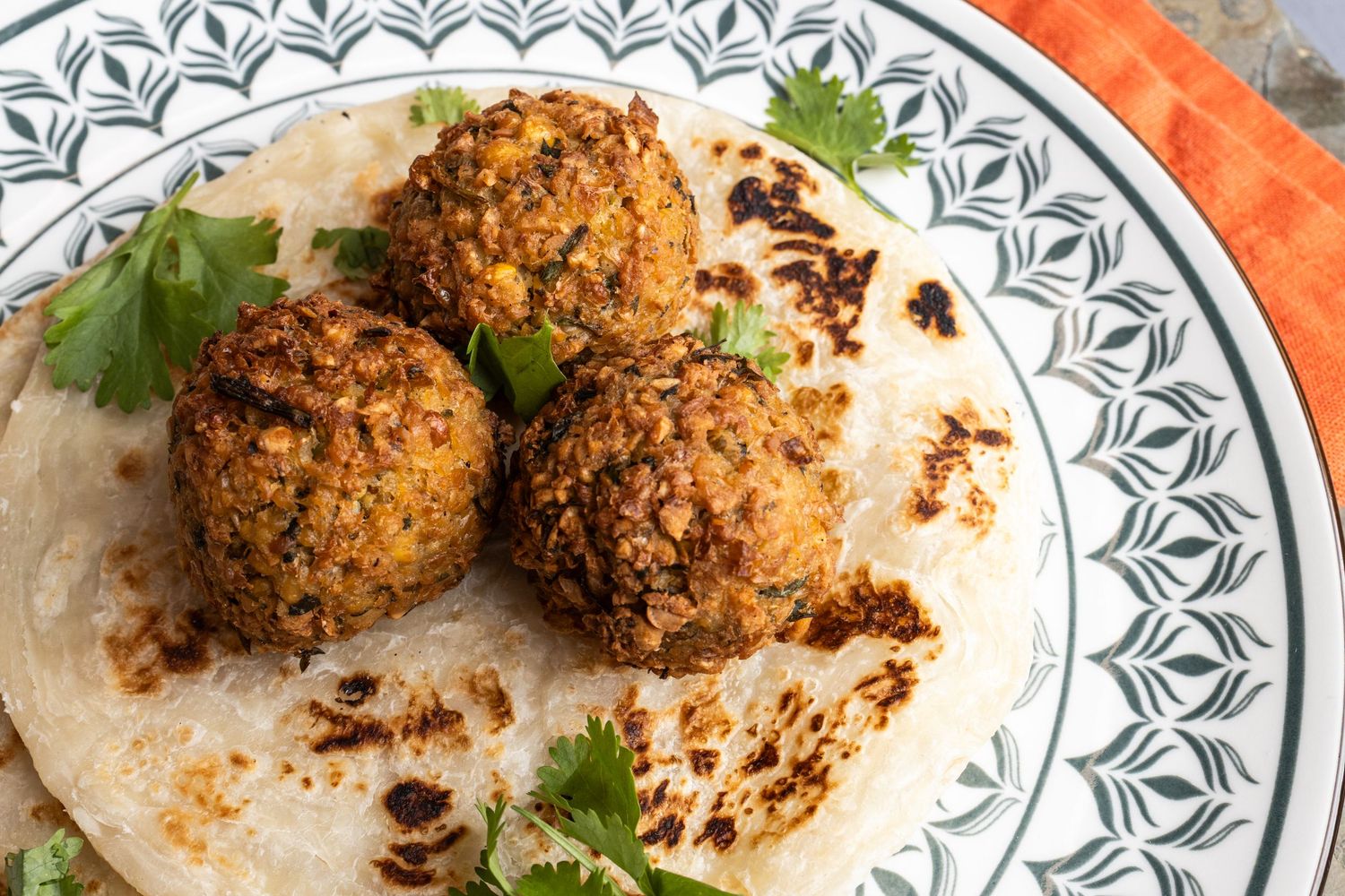 falafel balls and coriander laid on wrap on decorative plate