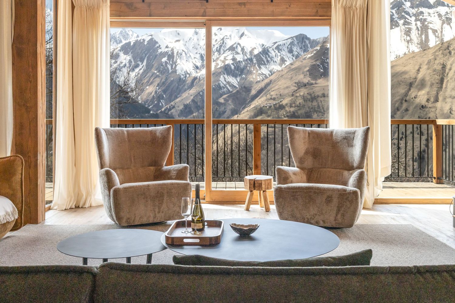 two chairs in front of a window with a view looking out onto snowy mountains
