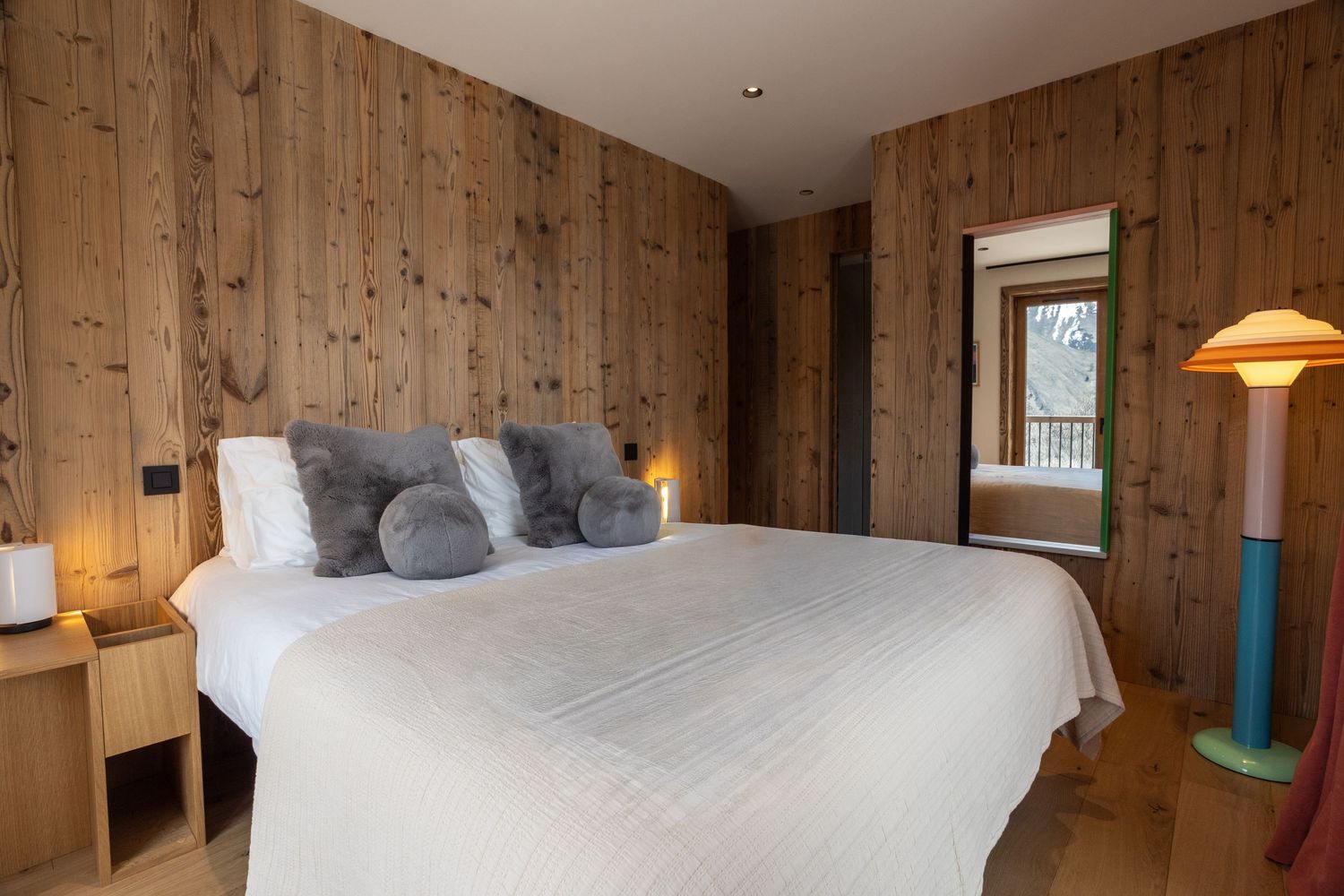 double bed in ski chalet with interesting floor lamp