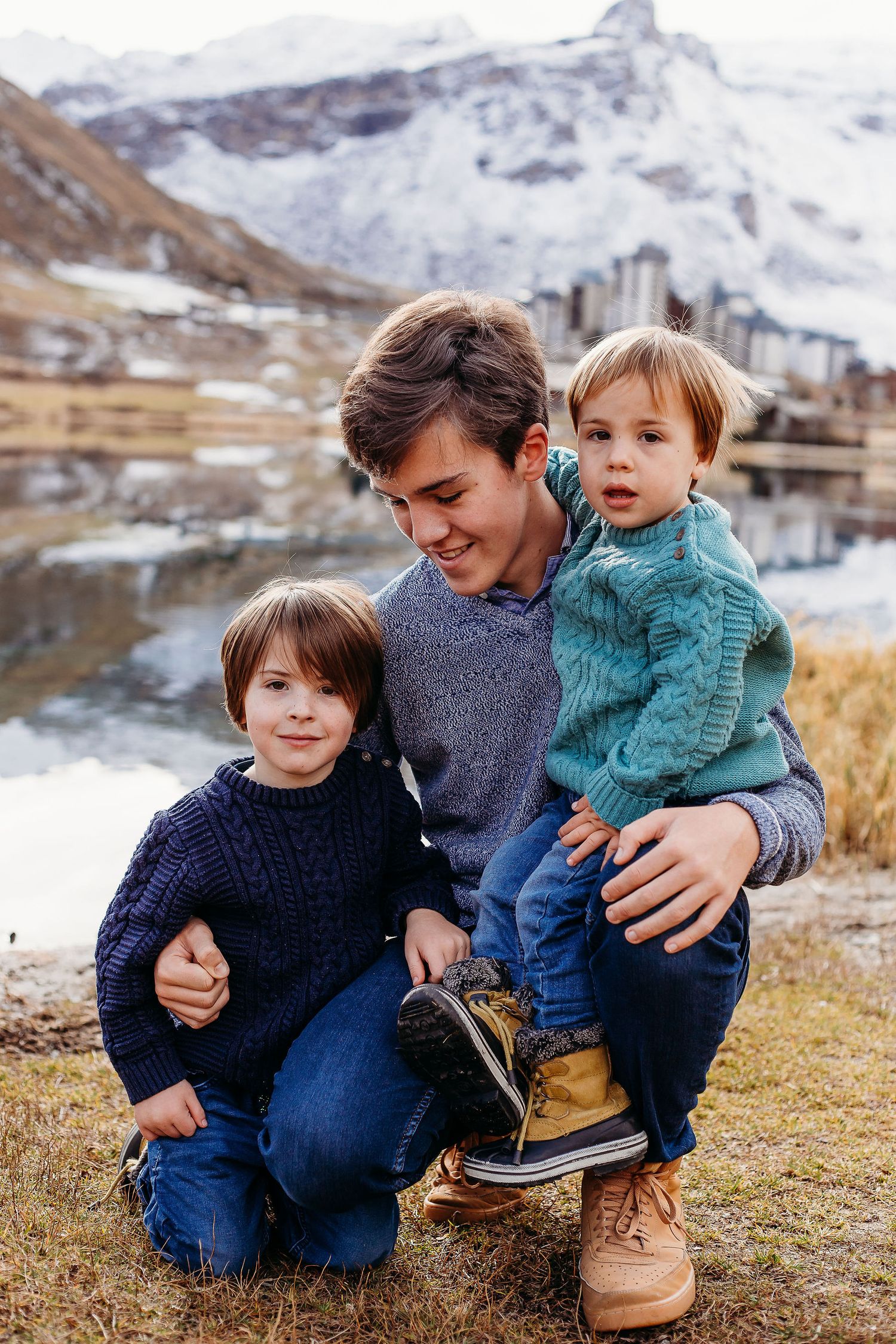 Three brothers pose in front of Tignes lake during autumn