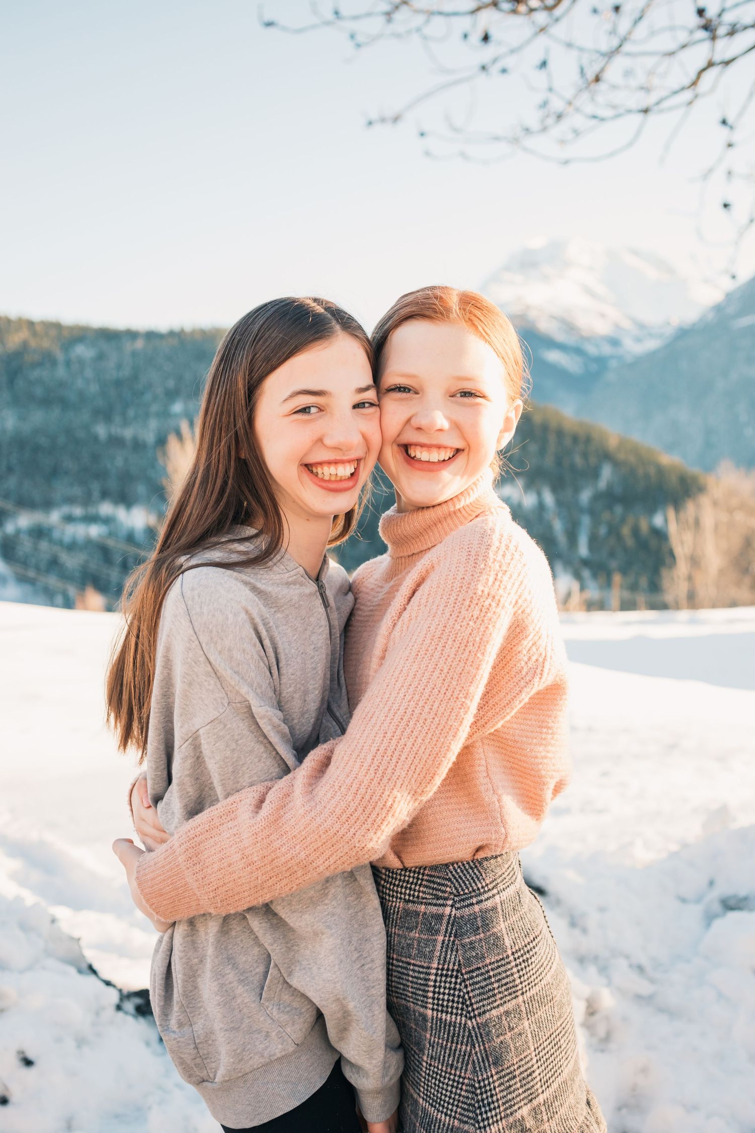 teenage sisters embrace in the snow