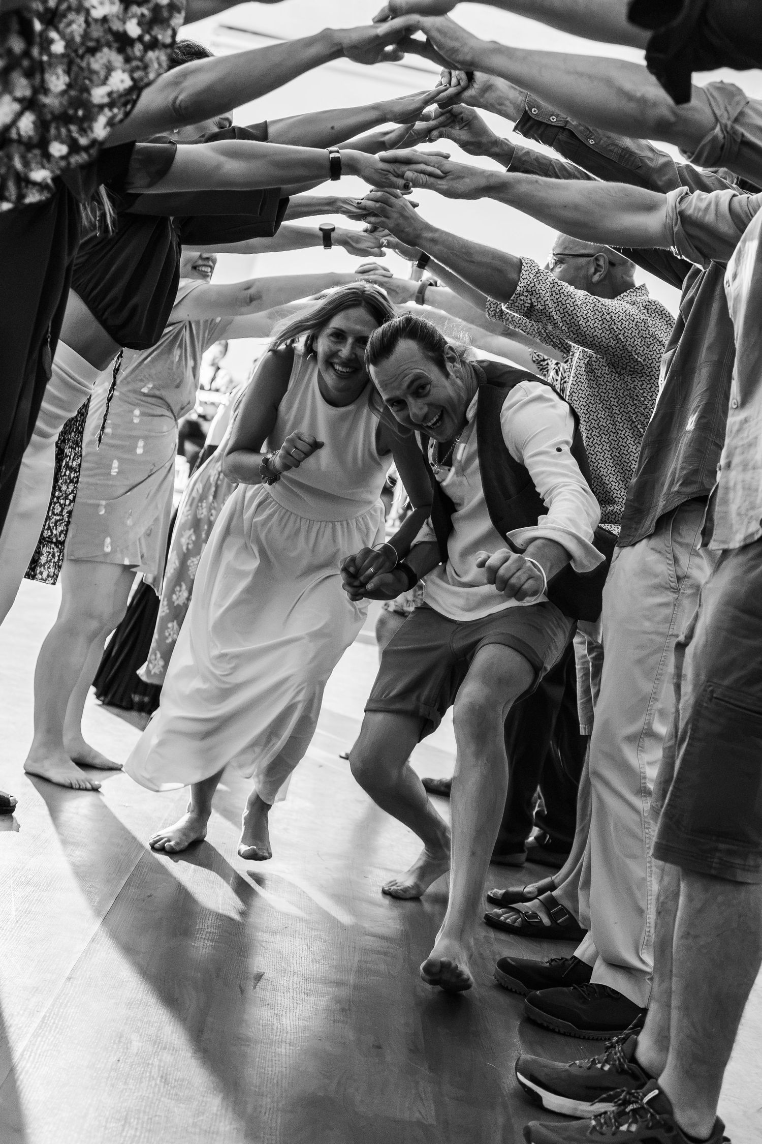 couple dances under crowds arms during Scottish dance