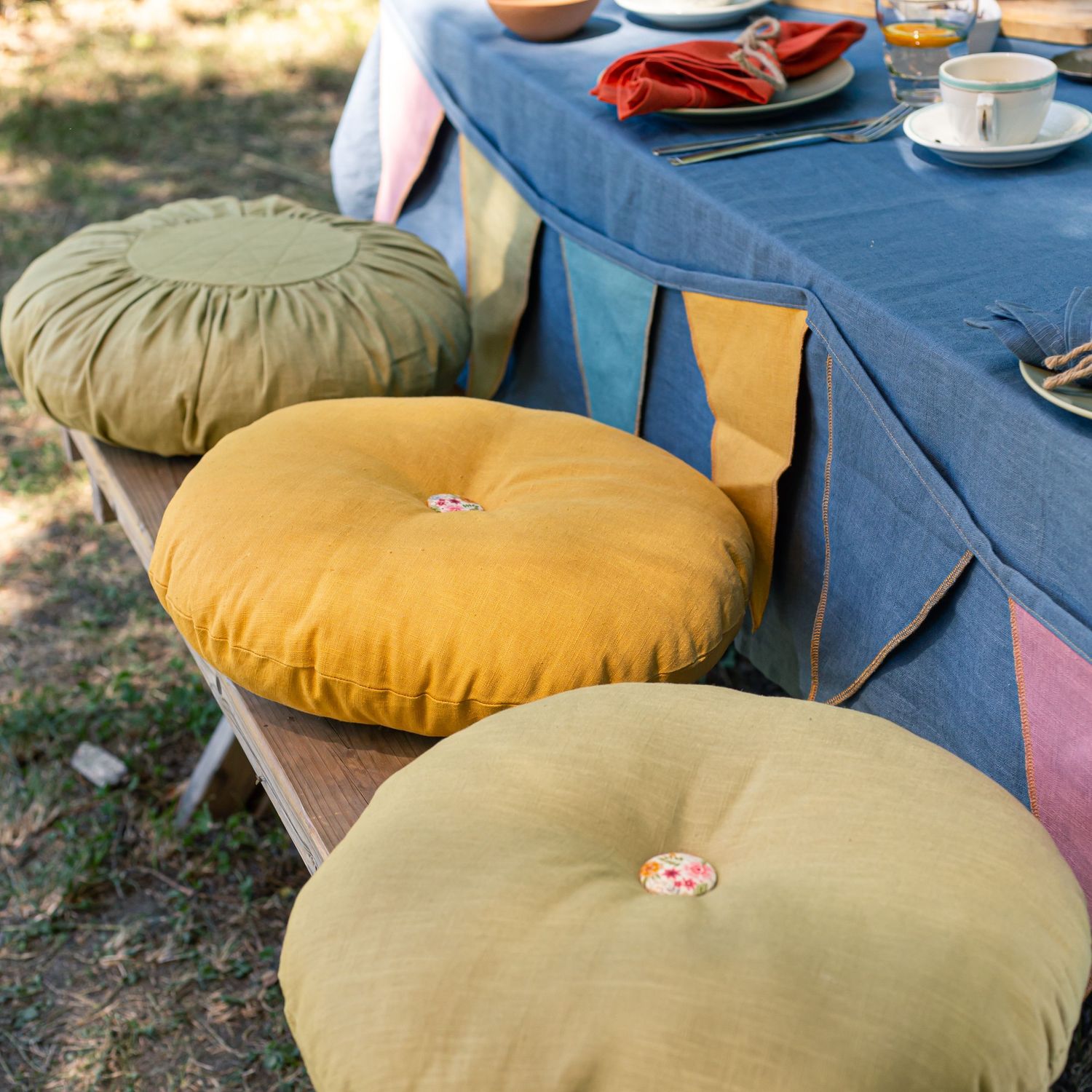 plush yellow and green cushions laying on picnic bench seat with bunting
