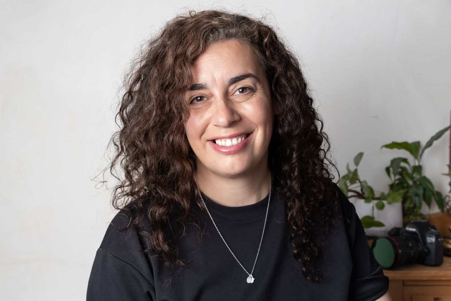 woman with curly hair smiles and looks at camera