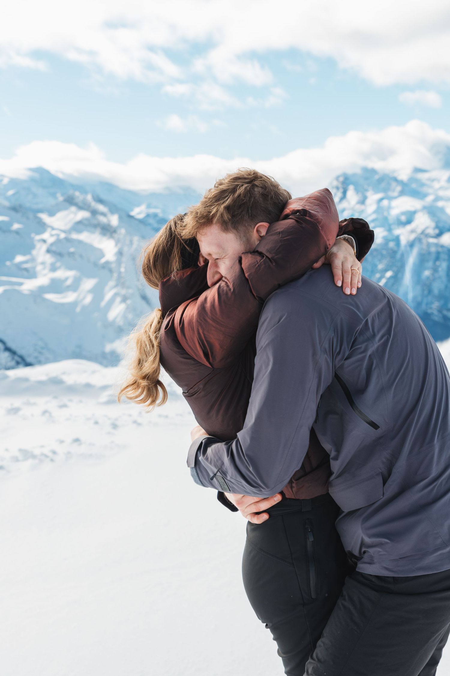 Couple hug after mountain top wedding proposal