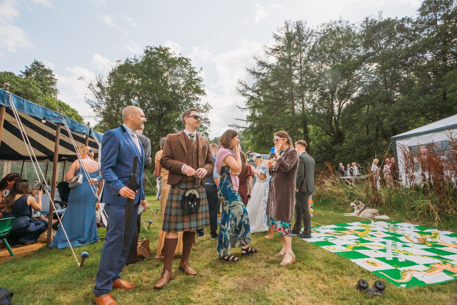 wedding guests standing next to garden game of snakes and ladders