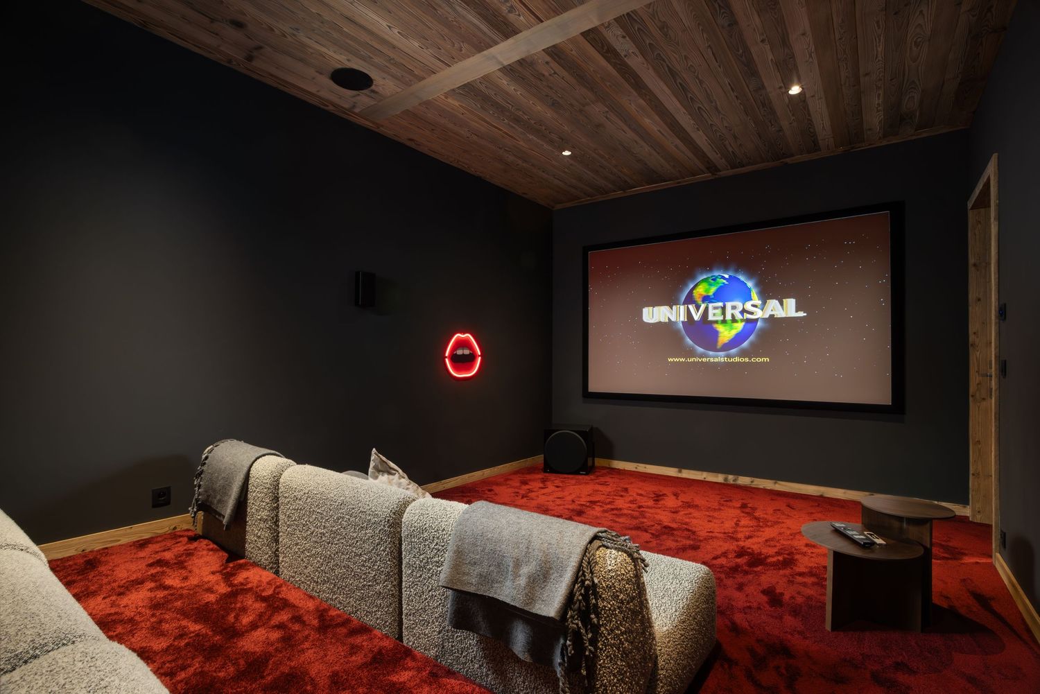 cinema room with red floor and two rows of seating in luxury ski chalet