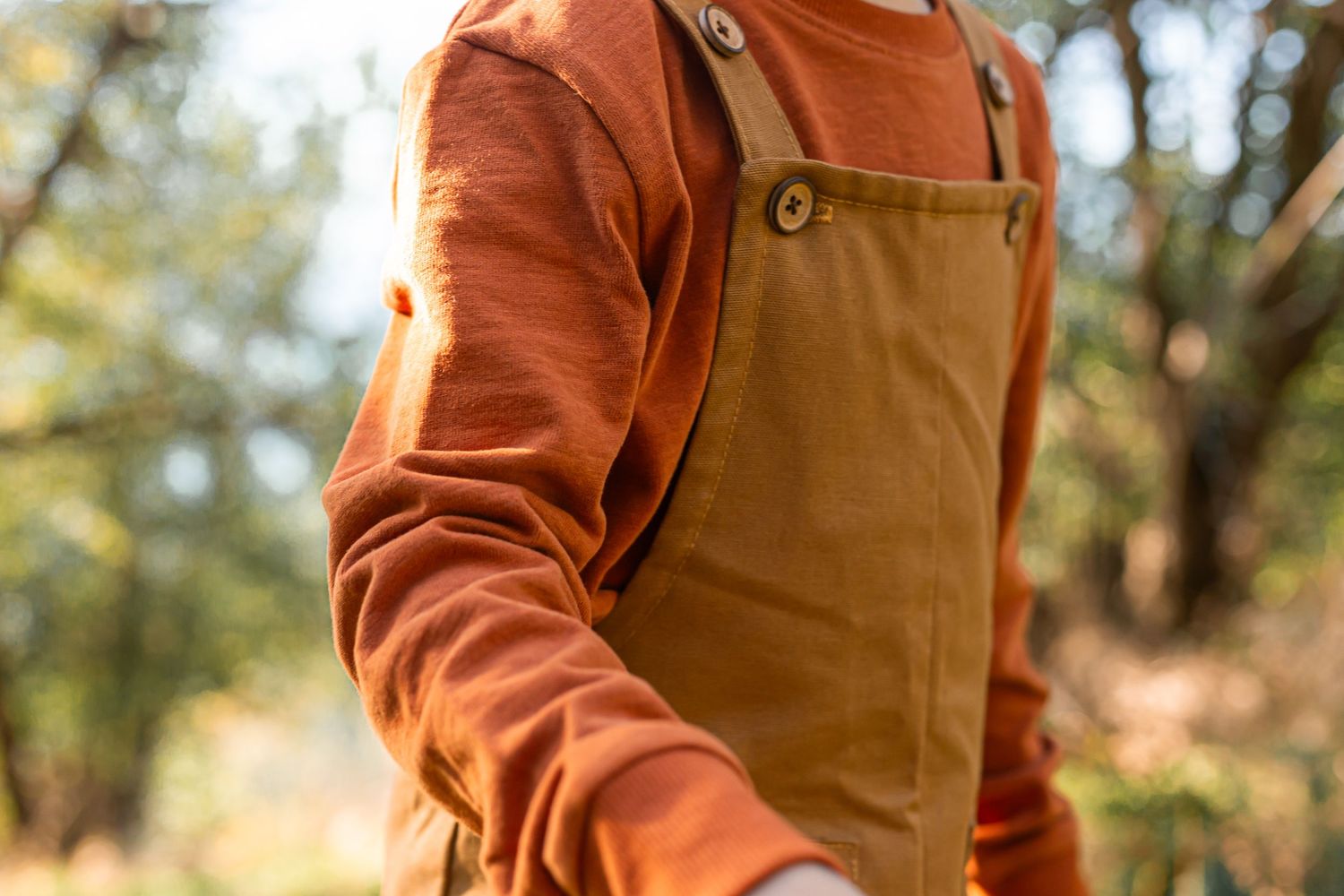 child wearing pair of orange linen dungarees