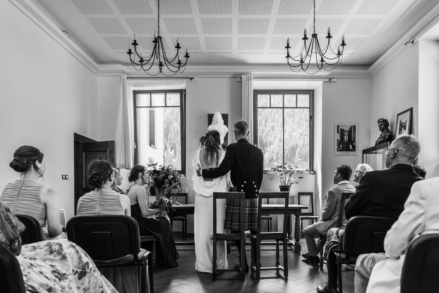 bride and groom stand at alter with their backs to all guests during wedding service