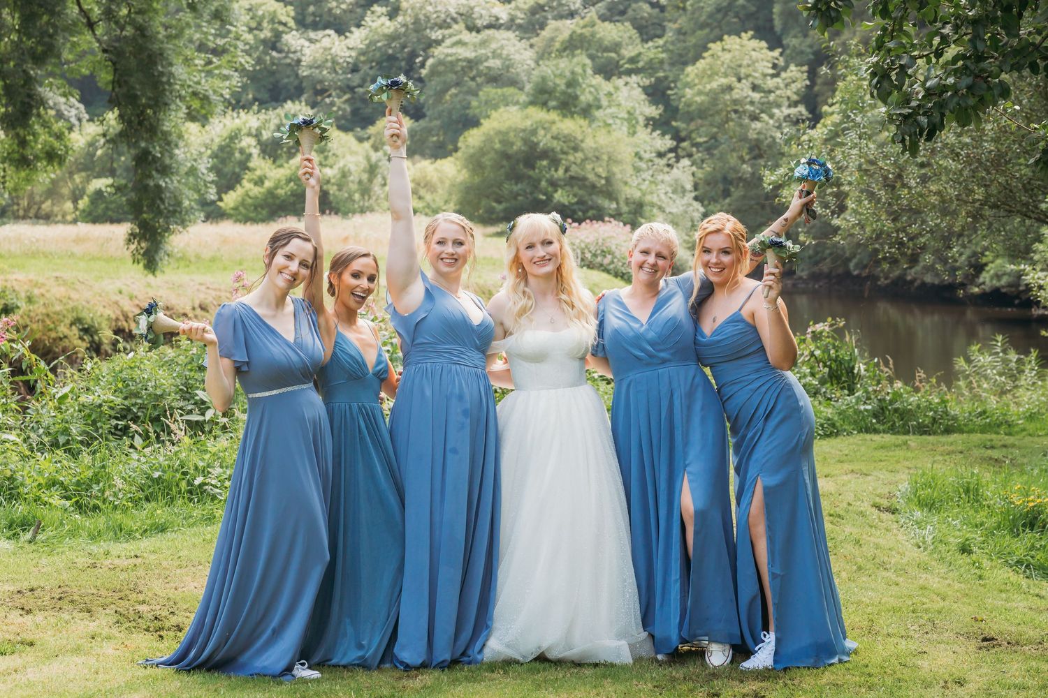 bride and bridesmaids cheering with bouquets in the air