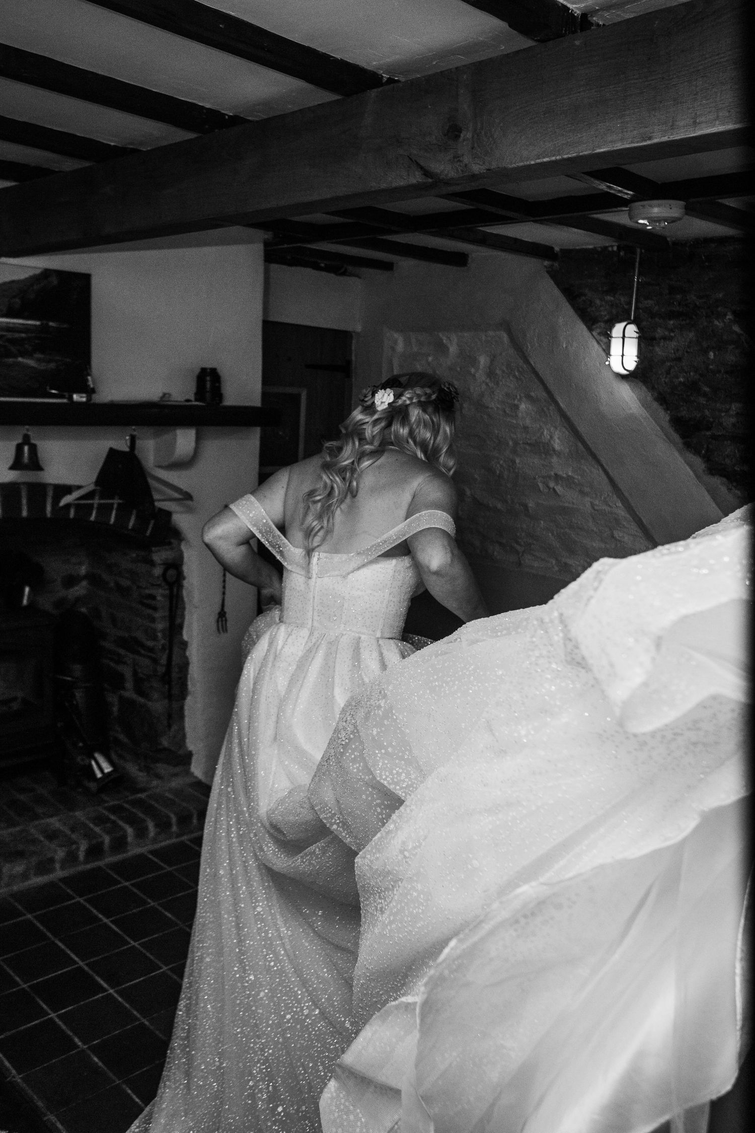 bride in wedding gown having Gawn fluffed up by sister